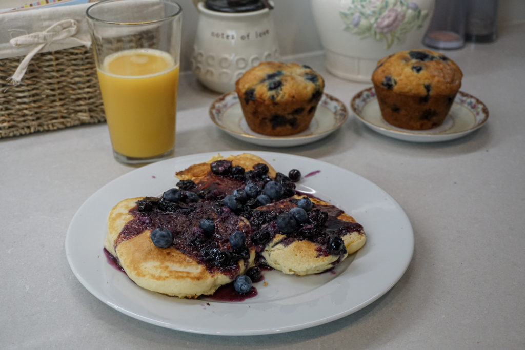 blueberry maple syrup pancakes with muffins and orange juice