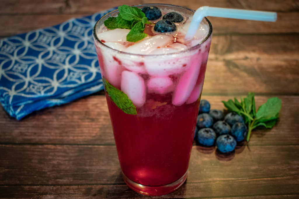 blueberry mojito in a glass with ice and mint and blueberries